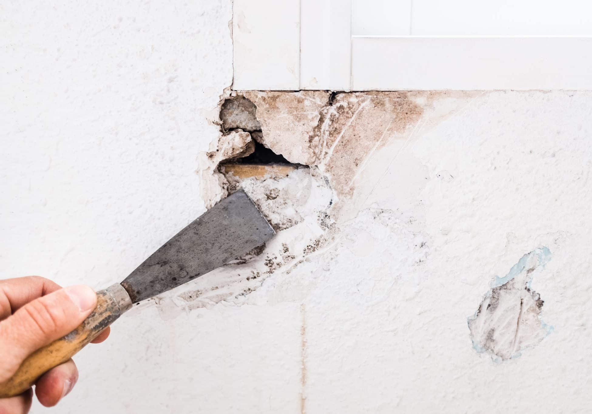 Detail of the repair of a hole in the wall of the living room using filling mass.